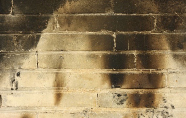 Smoke and soot damage on the wall of a house, caused by fire.